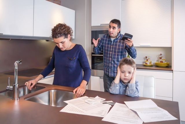 couple in kitchen arguing in front of child