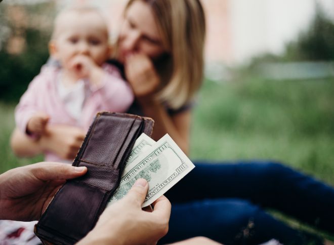 Person pulling child support money out of a wallet