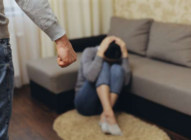 Person holding their head to protect themself from domestic violence
